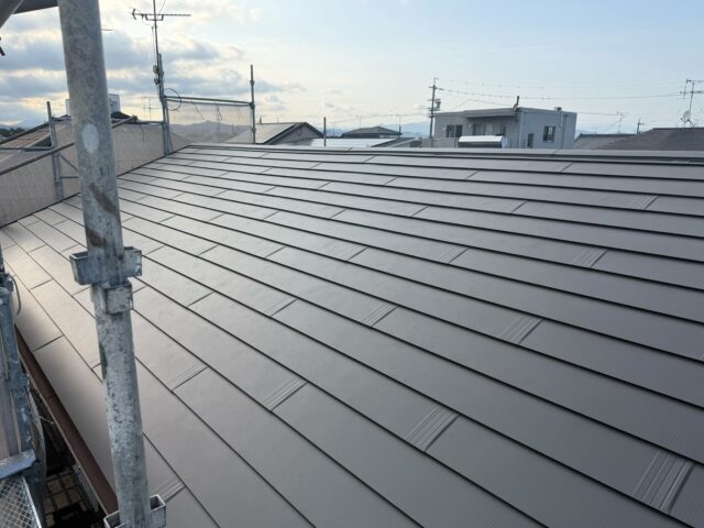 新しい屋根材の端部に板金を施工している様子