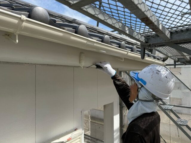島田市の外壁塗装工事で破風の下地を整えて塗装する職人