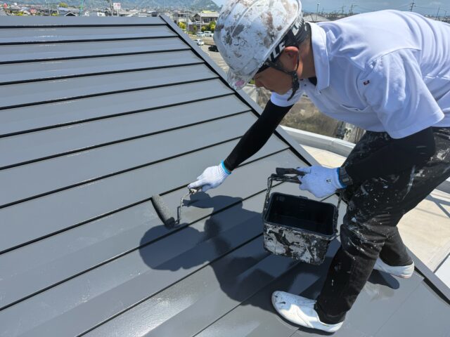 ガルバリウム鋼板屋根の上塗りを行っている様子